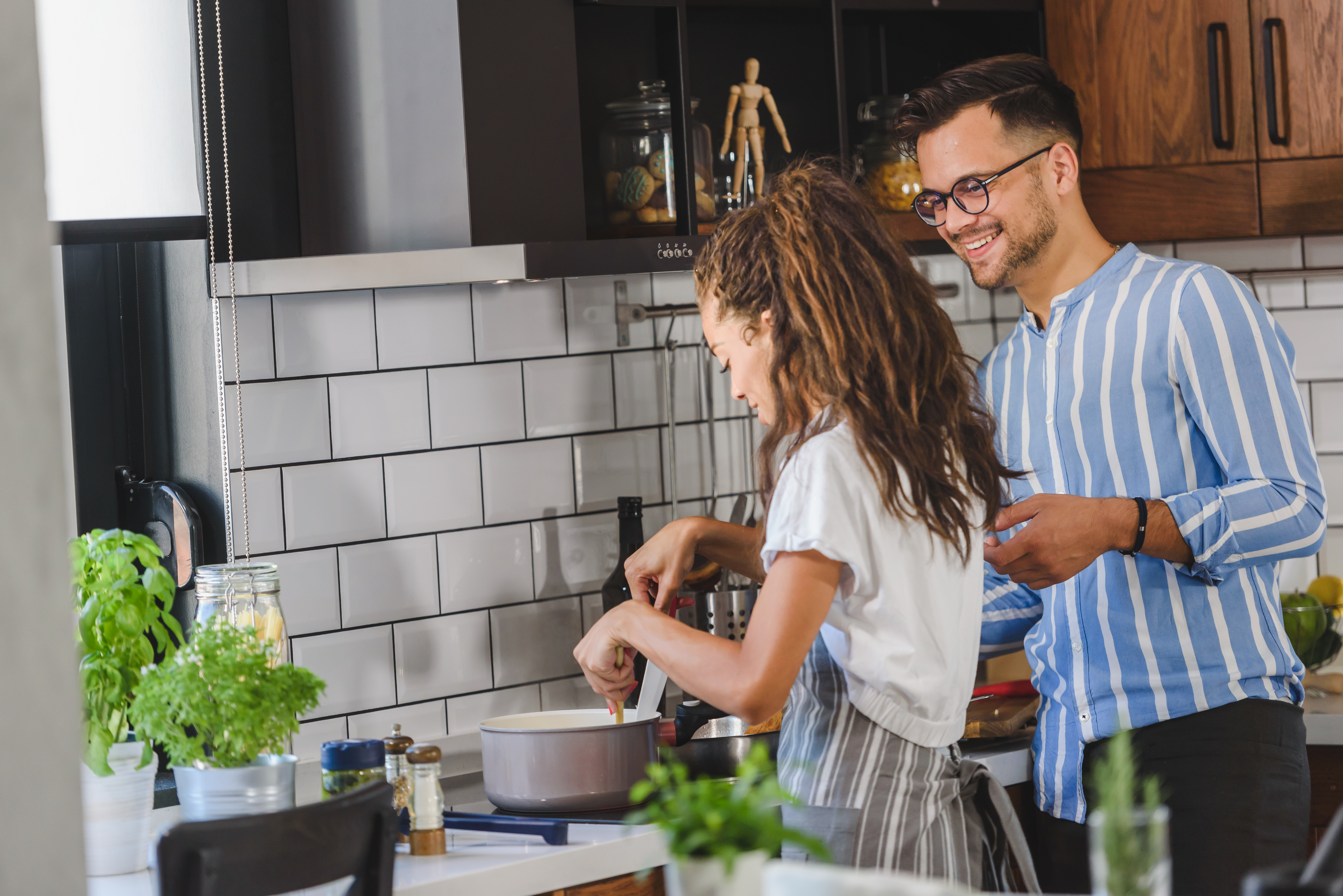 En tjej och en kille som står och lagar mat i ett kök