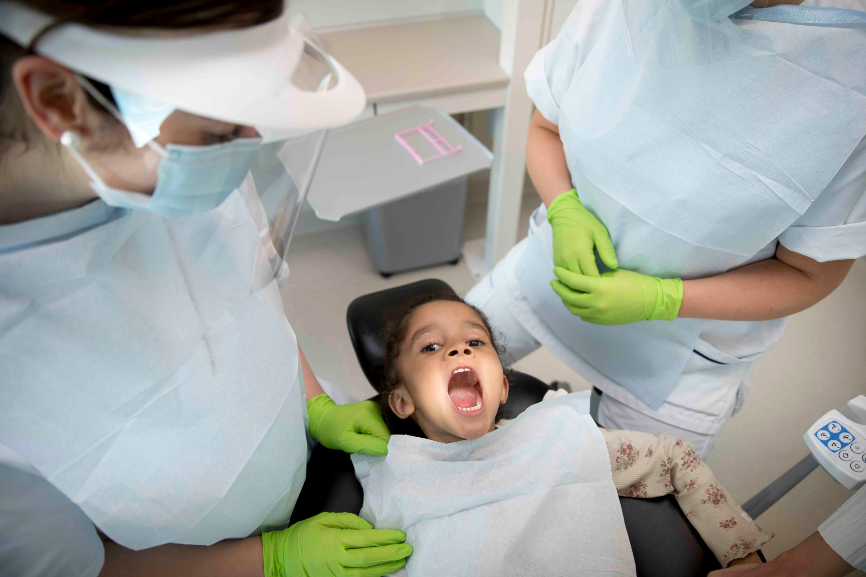 Barn i tandläkarstol gapar stort