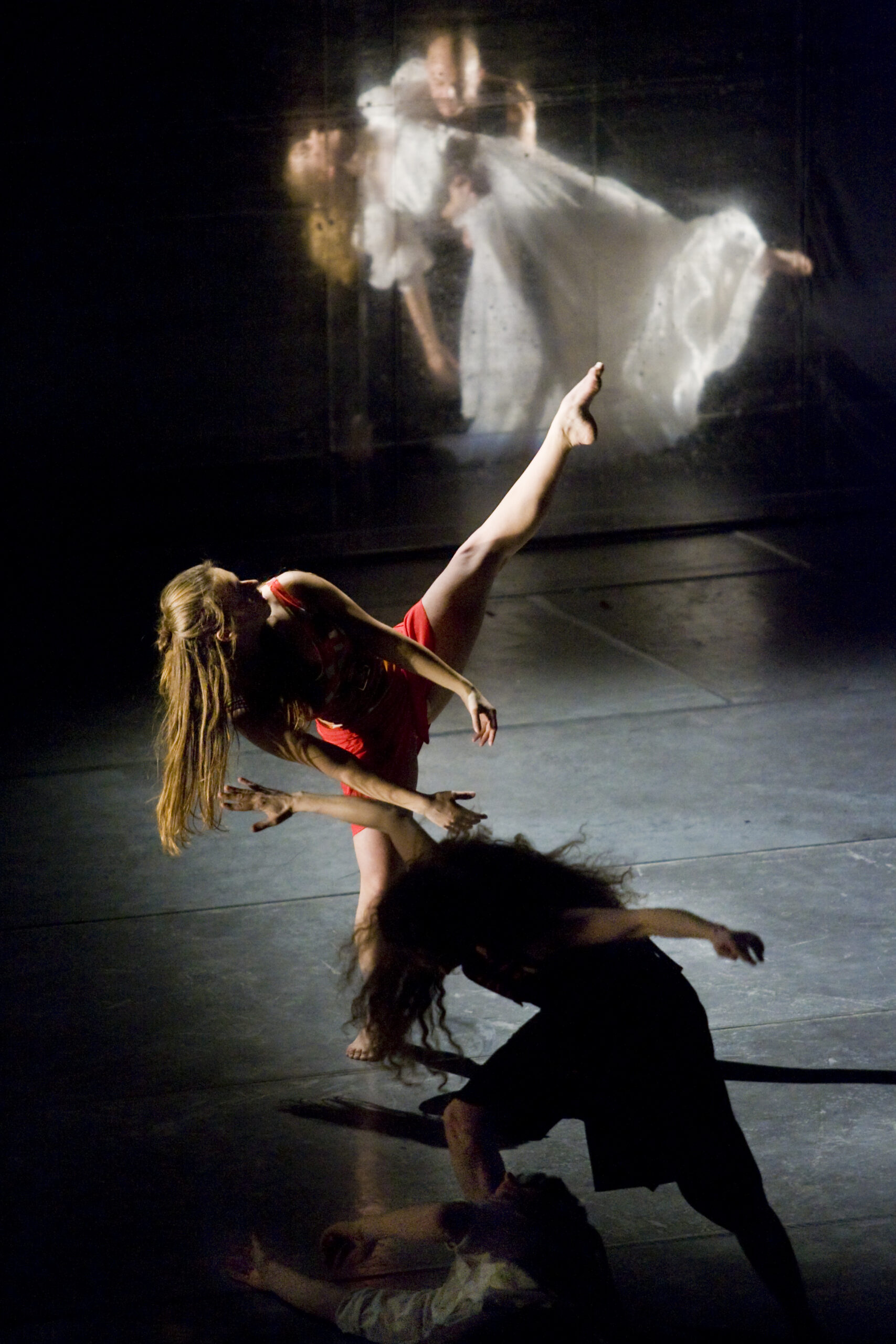 Dansare i olika poser och olika kostymer på en ljussatt scen